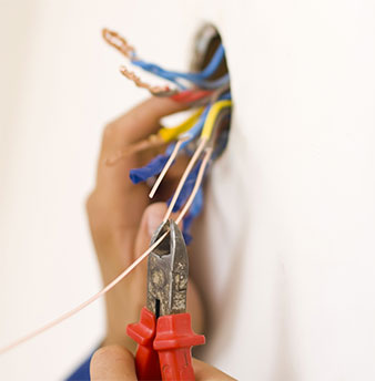 A hand clipping cables and wiring