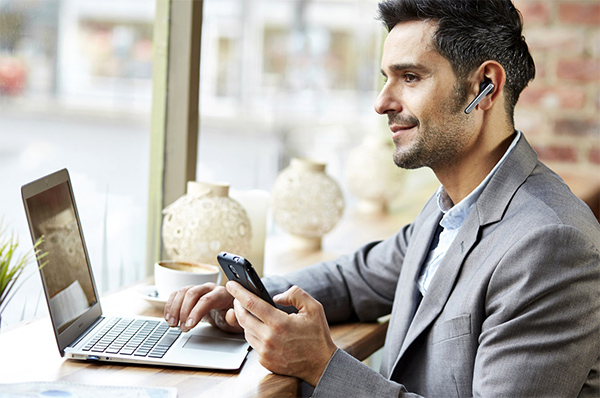 Man using AdcommTV Business Phone Service on his phone and his laptop