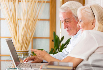 View of two senior citizens enjoying TV & Internet in Senior Living